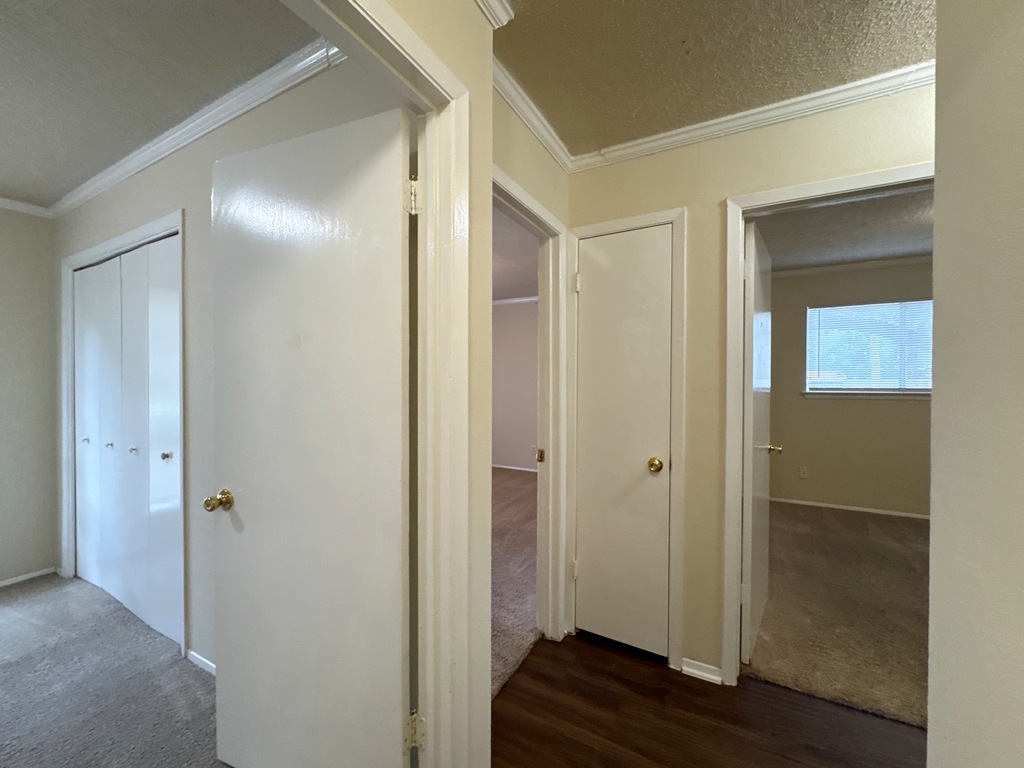 5905 Burrough Drive Austin, TX 78745 - Photo 18 of 40 Hall featuring crown molding, dark carpet, and dark wood-type flooring