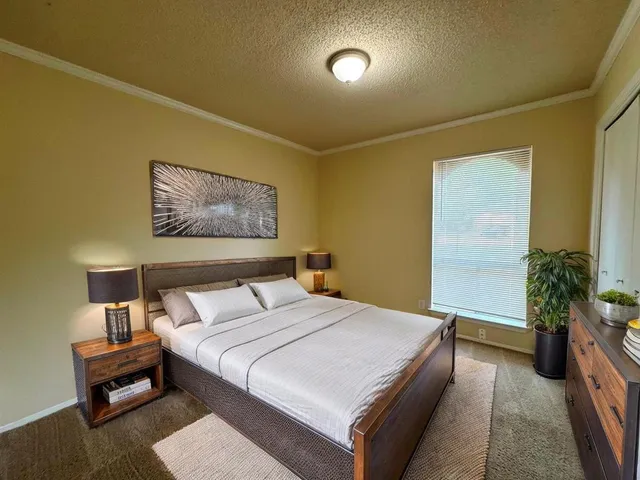 a bedroom with a bed and a potted plant