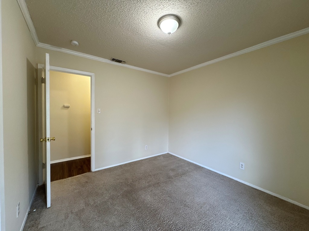 5905 Burrough Drive Austin, TX 78745 - Photo 22 of 40 Carpeted empty room featuring crown molding and a textured ceiling
