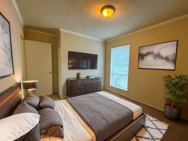 a bedroom with a bed and a flat screen tv