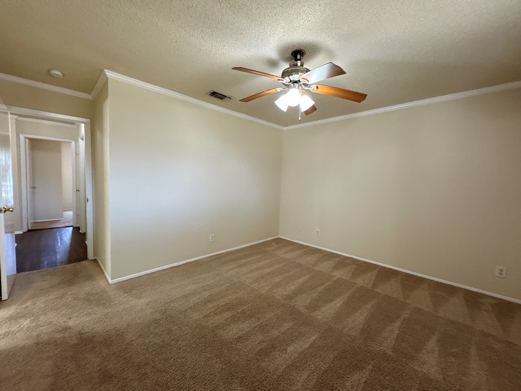 5905 Burrough Drive Austin, TX 78745 - Photo 37 of 40 Unfurnished room with ornamental molding, a textured ceiling, carpet floors, and a ceiling fan