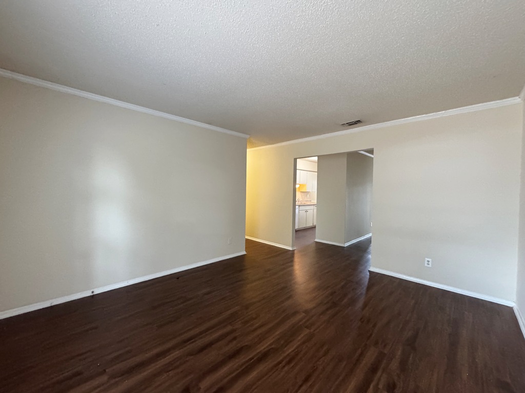 5905 Burrough Drive Austin, TX 78745 - Photo 4 of 40 Spare room with ornamental molding, dark wood finished floors, and a textured ceiling