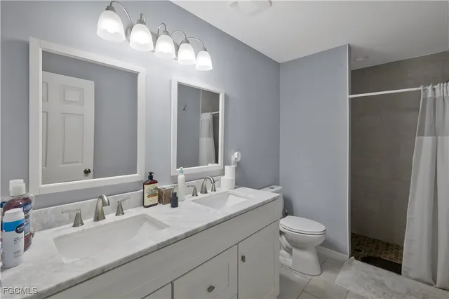 a bathroom with a sink vanity granite and toilet