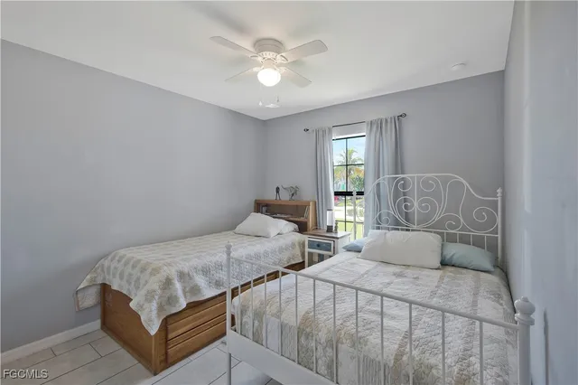 a bedroom with two beds and window