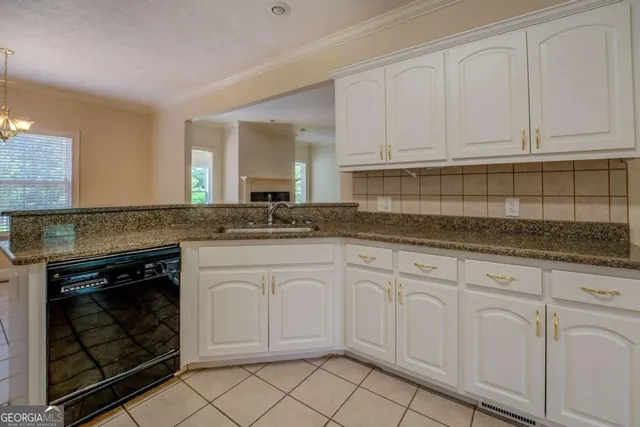 a kitchen with white cabinets granite counter tops and a stove