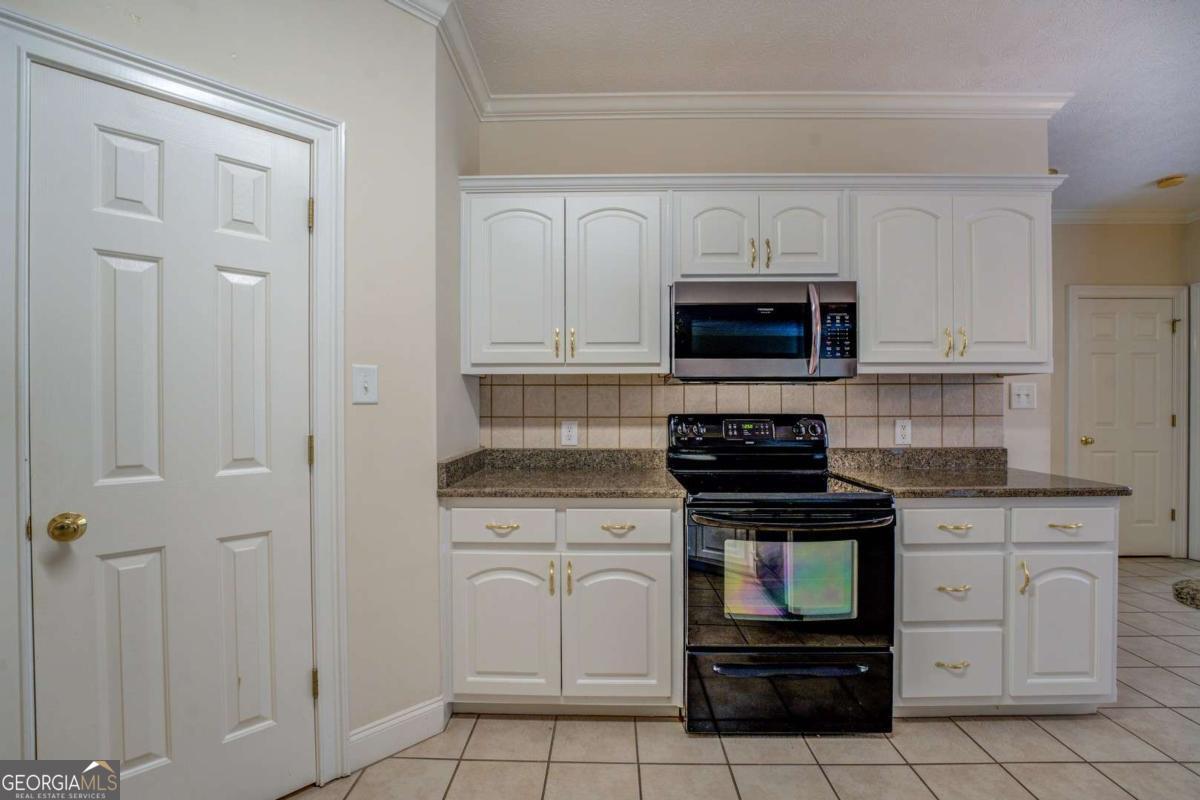 212 Willow Ridge Lane Jackson, GA 30233 - Photo 25 of 45 a kitchen with white cabinets and stainless steel appliances