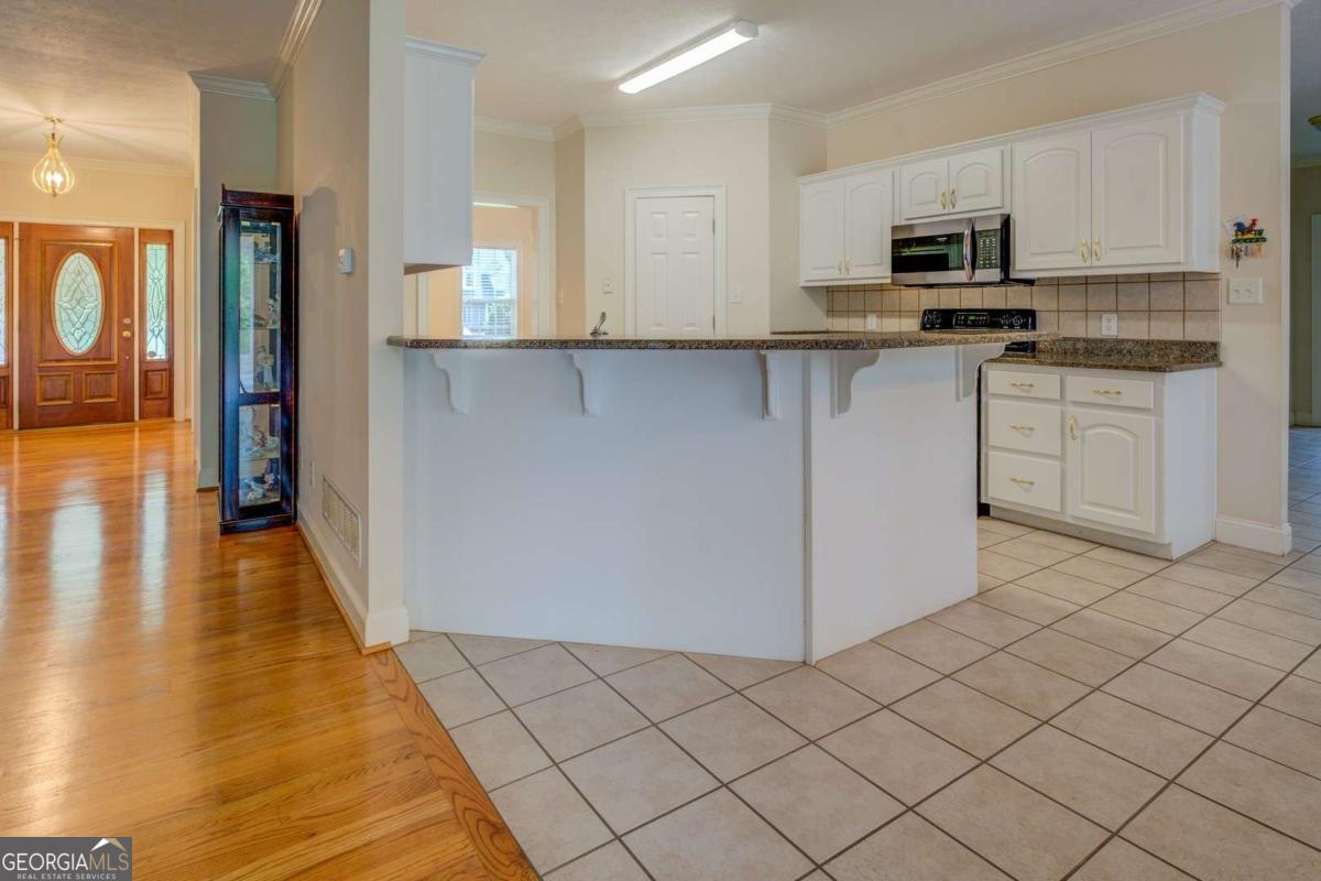 212 Willow Ridge Lane Jackson, GA 30233 - Photo 29 of 45 a kitchen with stainless steel appliances granite countertop a stove a sink and a refrigerator