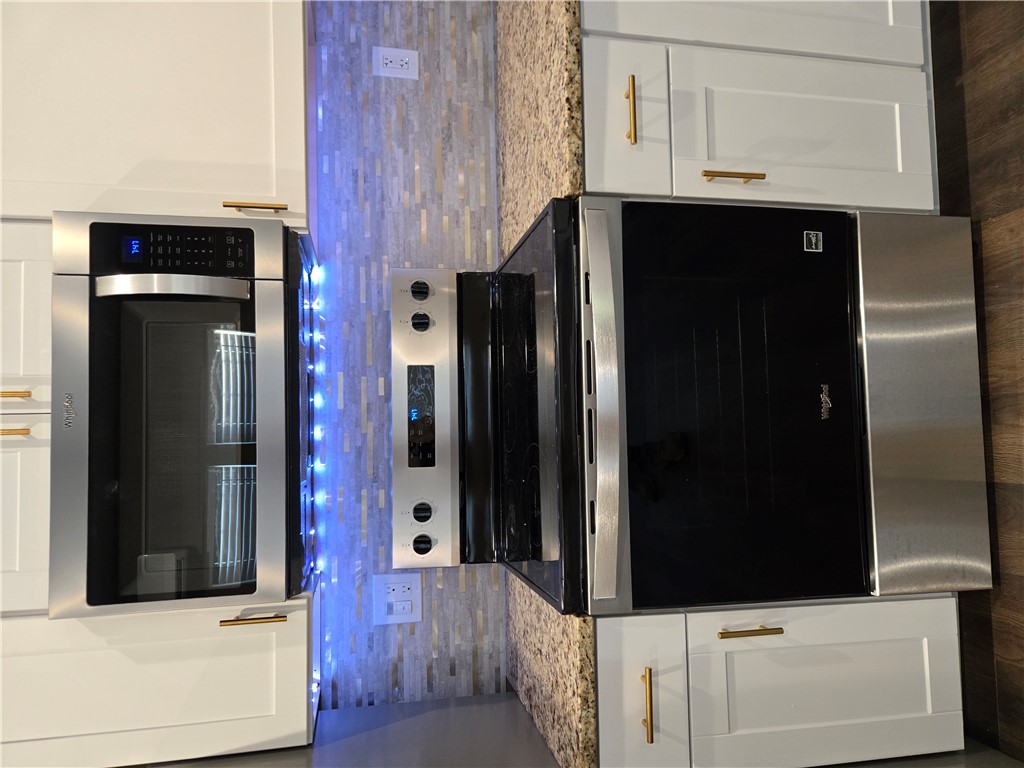 28 Ames Street Seneca, SC 29678 - Photo 9 of 22 Modern stainless steel appliances pair with granite countertops and a tiled backsplash.