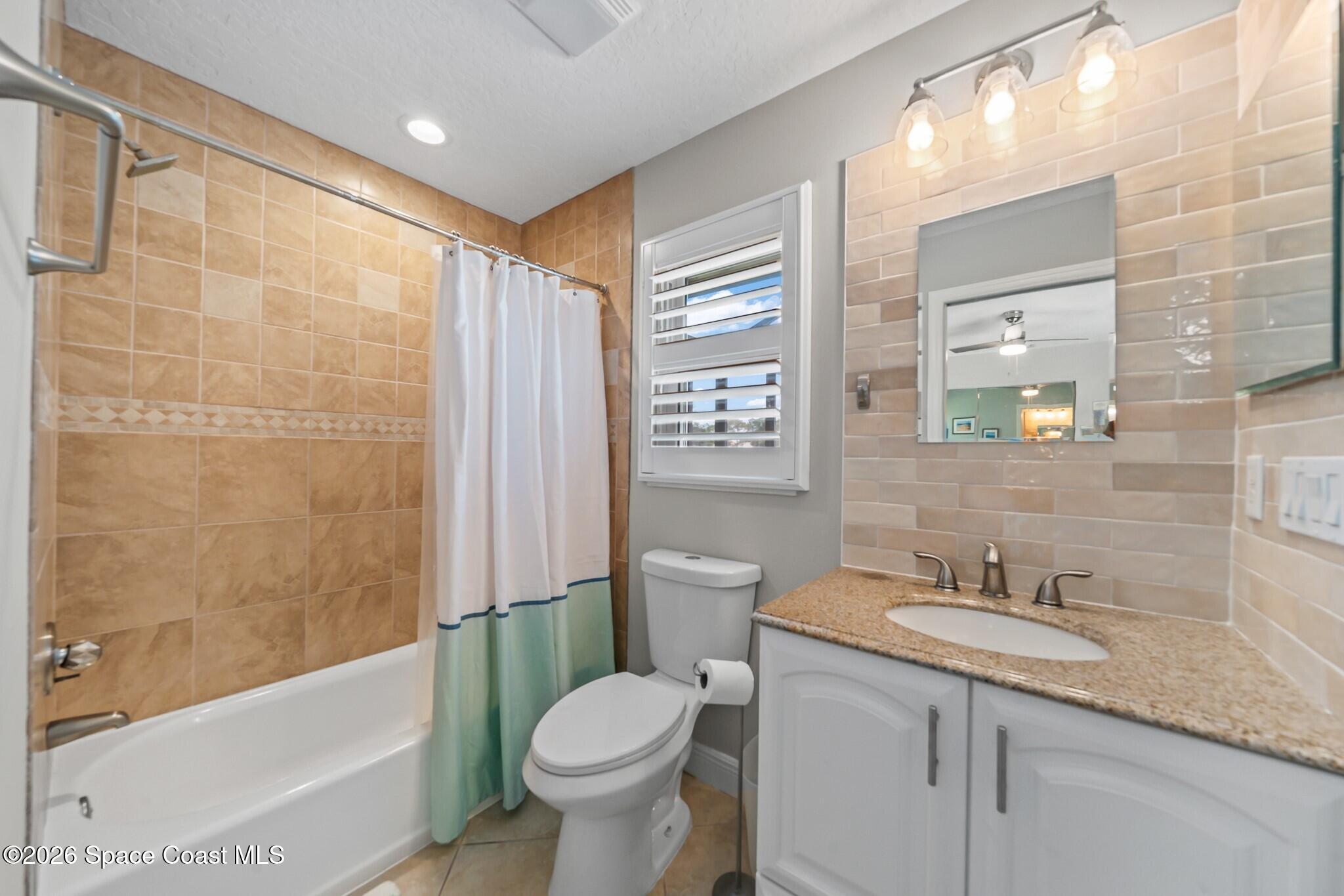 697 Spring Lake Drive Melbourne, FL 32940 - Photo 27 of 45 a bathroom with a granite countertop sink toilet and shower