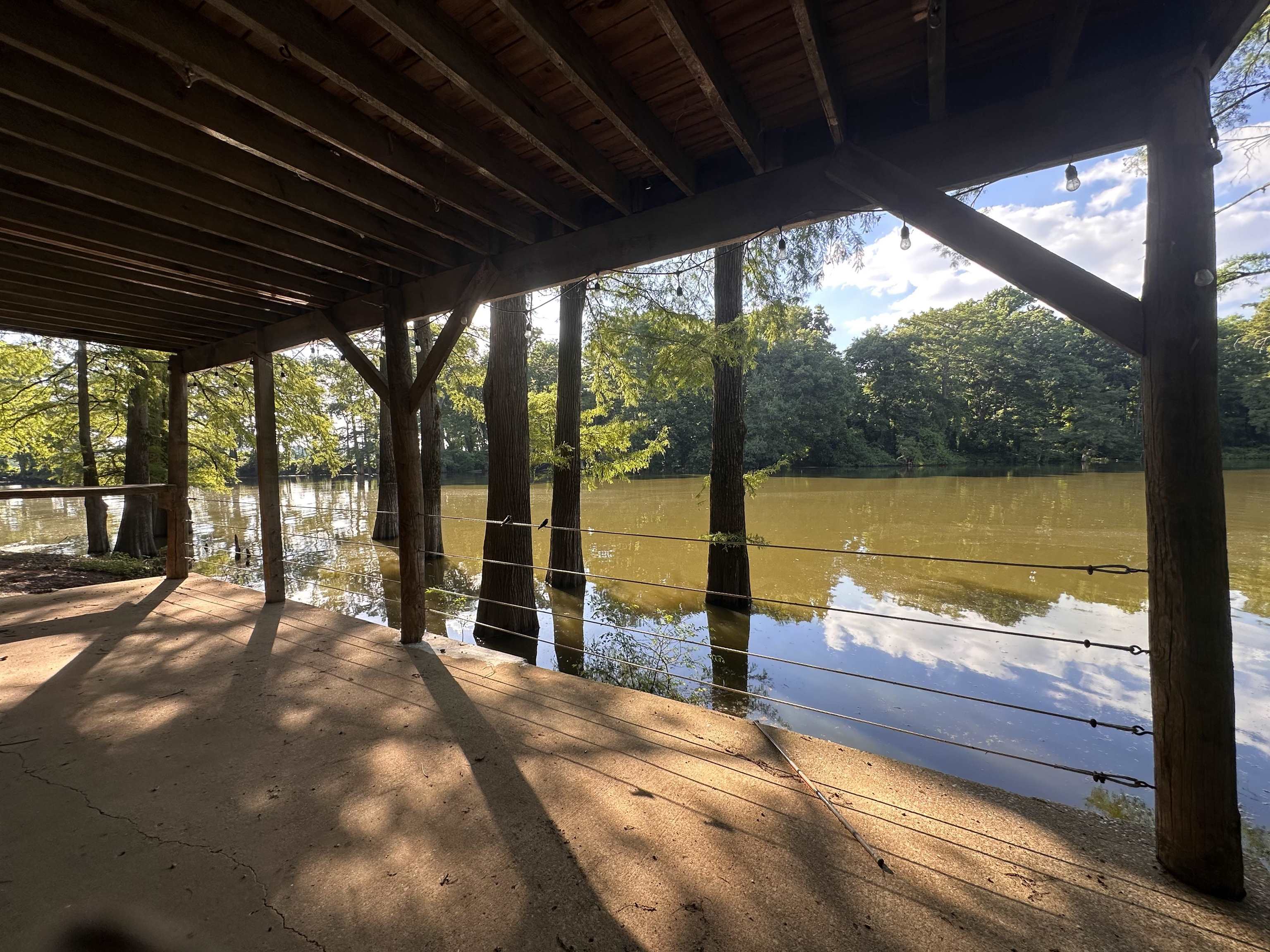 481 Chisholm Lake Camp Road Ripley, TN 38063 - Photo 2 of 12 Covered patio with an exposed wood beam ceiling, concrete flooring, and string lighting