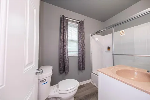 a bathroom with a sink a toilet a mirror and shower