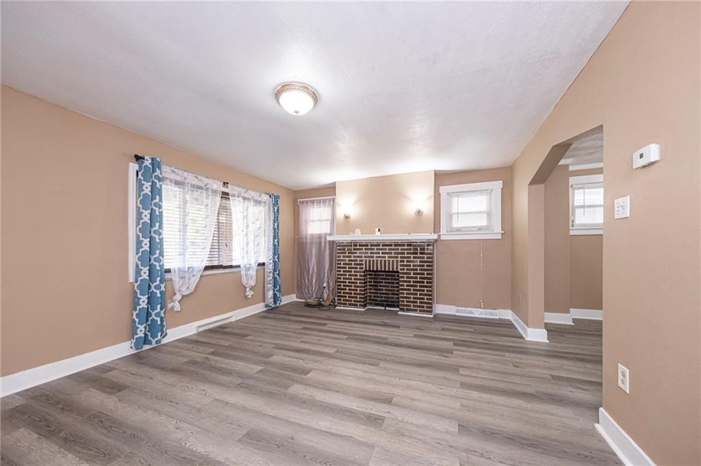 1536 Hunter Street Pittsburgh, PA 15221 - Photo 3 of 18 an empty room with windows fireplace and wooden floor