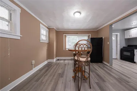 a view of a room with wooden floor table and windows