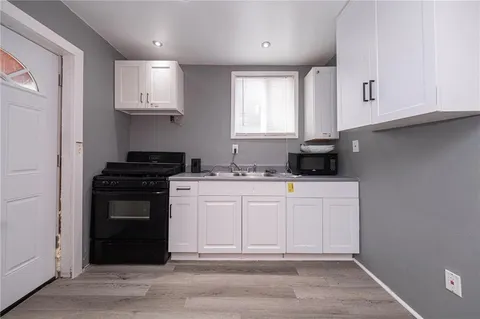 a kitchen with stainless steel appliances granite countertop a stove a sink and a microwave