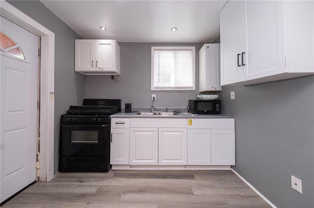1536 Hunter Street Pittsburgh, PA 15221 - Photo 7 of 18 a kitchen with stainless steel appliances granite countertop a stove a sink and a microwave
