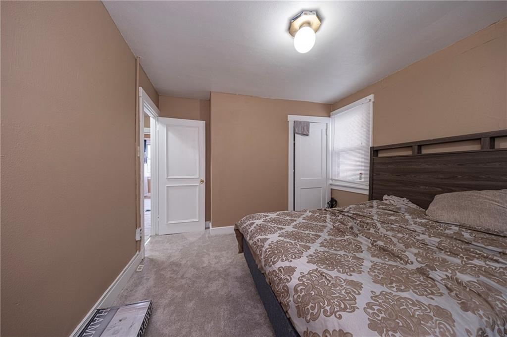 1536 Hunter Street Pittsburgh, PA 15221 - Photo 8 of 18 a bedroom with a large bed and a chandelier