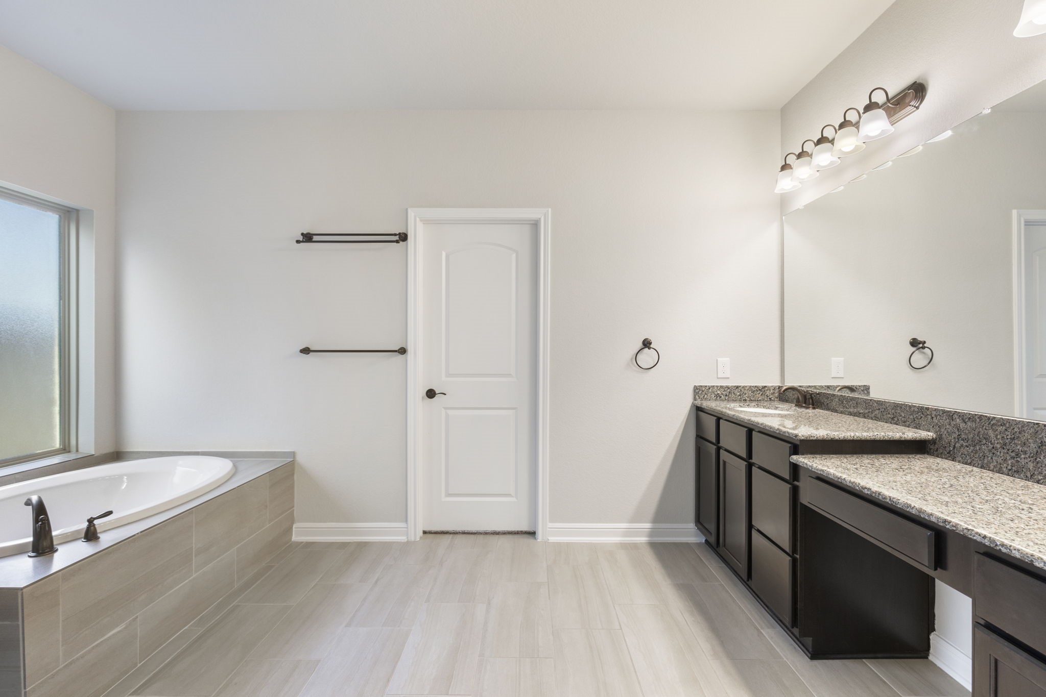 2819 Bradbury Hills Road Spring, TX 77373 - Photo 29 of 50 Discover a serene oasis in this primary bathroom, featuring a spacious soaking tub, elegant dual vanities with granite countertops, and sleek modern fixtures, perfect for unwinding in style.