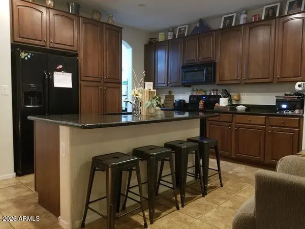 a kitchen with kitchen island granite countertop wooden cabinets and stainless steel appliances