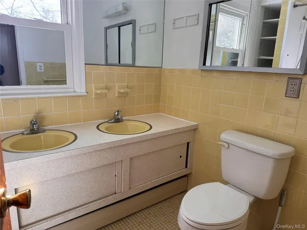 a bathroom with a toilet a sink and mirror