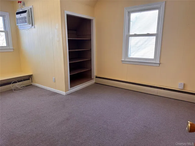 an empty room with a window and closet