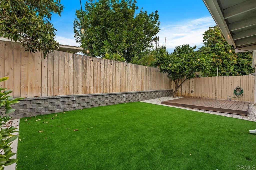 3518 Capalina Road San Marcos, CA 92069 - Photo 32 of 34 a view of a backyard with a large tree and wooden fence