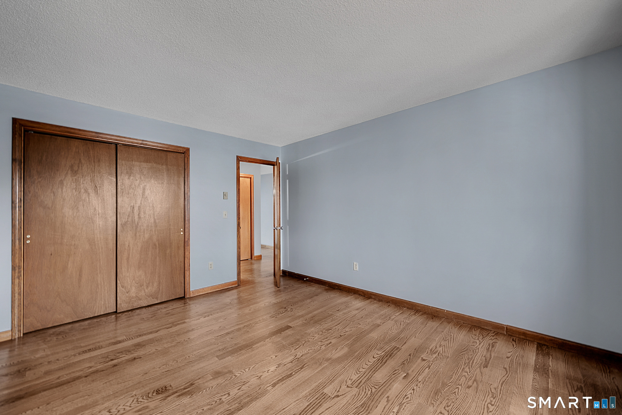 81 Chipman Street, Unit 13 Waterbury, CT 06708 - Photo 7 of 11 a view of an empty room with wooden floor and a window