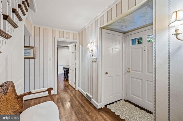 a view of a hallway with bathroom and wooden floor