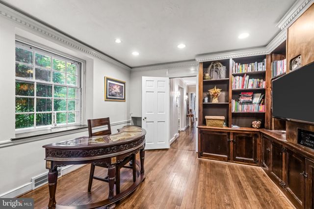 a view of a workspace with furniture and a book shelf