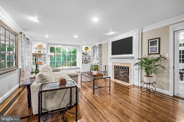 a living room with furniture a fireplace a flat screen tv and a large window