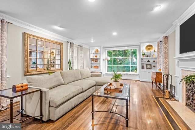 a living room with fireplace furniture and a large window