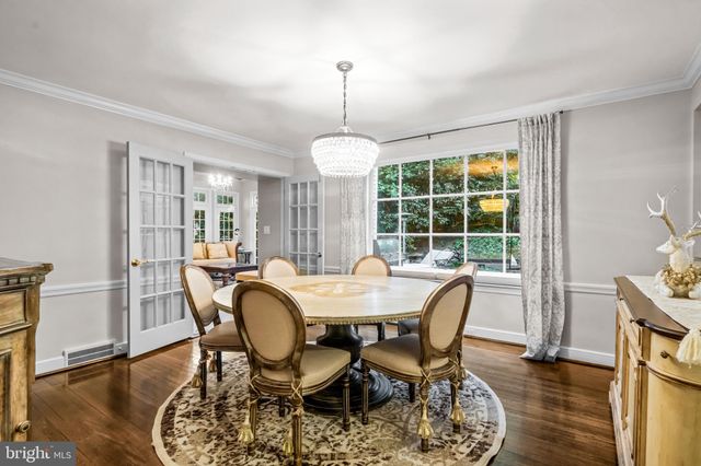 a dining room with furniture a chandelier and wooden floor