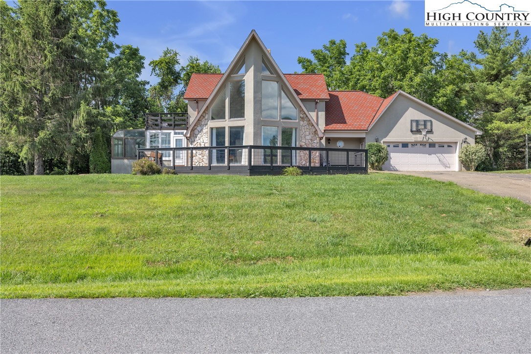 a view of a house with a yard and potted plants