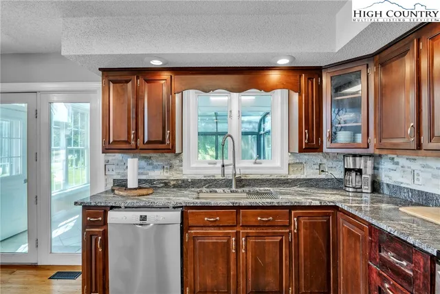 a kitchen with large windows and cabinets