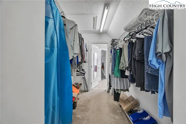 a view of walk in closet with clothes