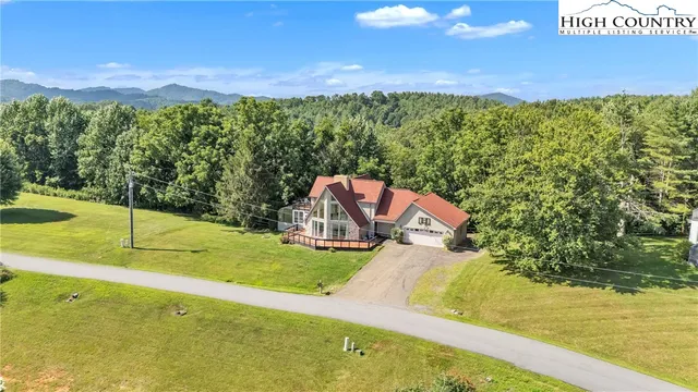 a backyard of a house with yard seating area and trees in the background