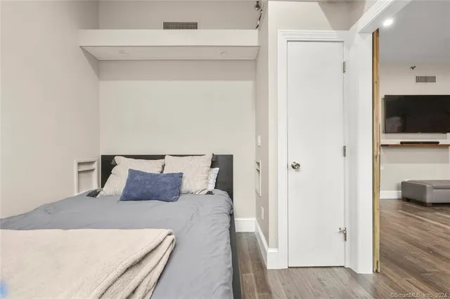 a bedroom with a bed and a flat screen tv