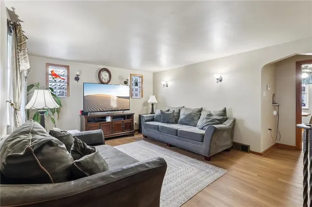 a kitchen with stainless steel appliances granite countertop a stove a sink a dining table and chairs with wooden floor