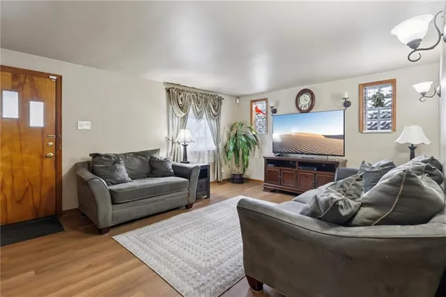 a kitchen with stainless steel appliances granite countertop a stove a refrigerator a sink a dining table and chairs