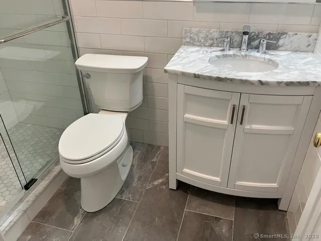 a white toilet sitting next to a bathroom sink