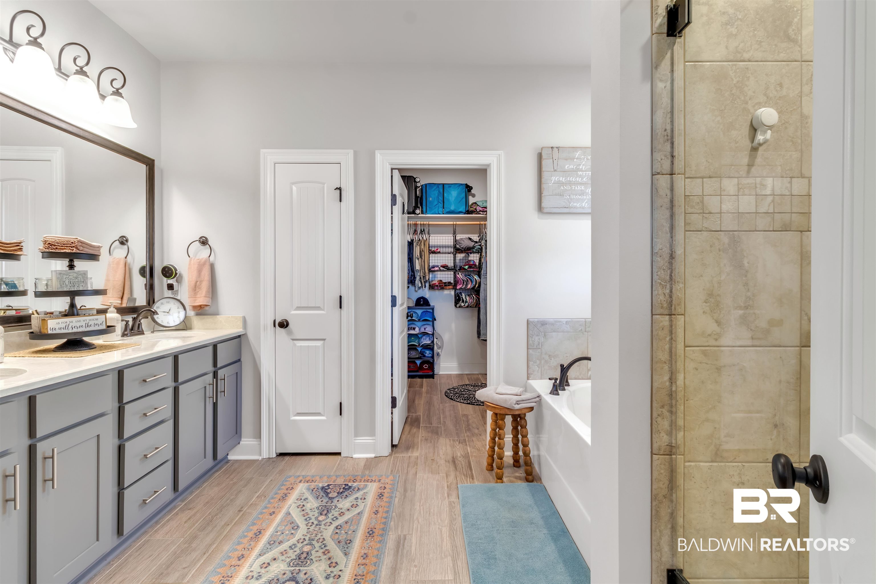 22531 Putter Lane Foley, AL 36535 - Photo 22 of 43 Full bath with a spacious closet, double vanity, a bath, a shower stall, and light wood-style flooring