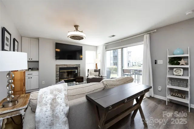 a living room with furniture a flat screen tv and a fireplace