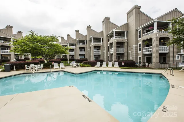 a swimming pool with outdoor seating and a garden