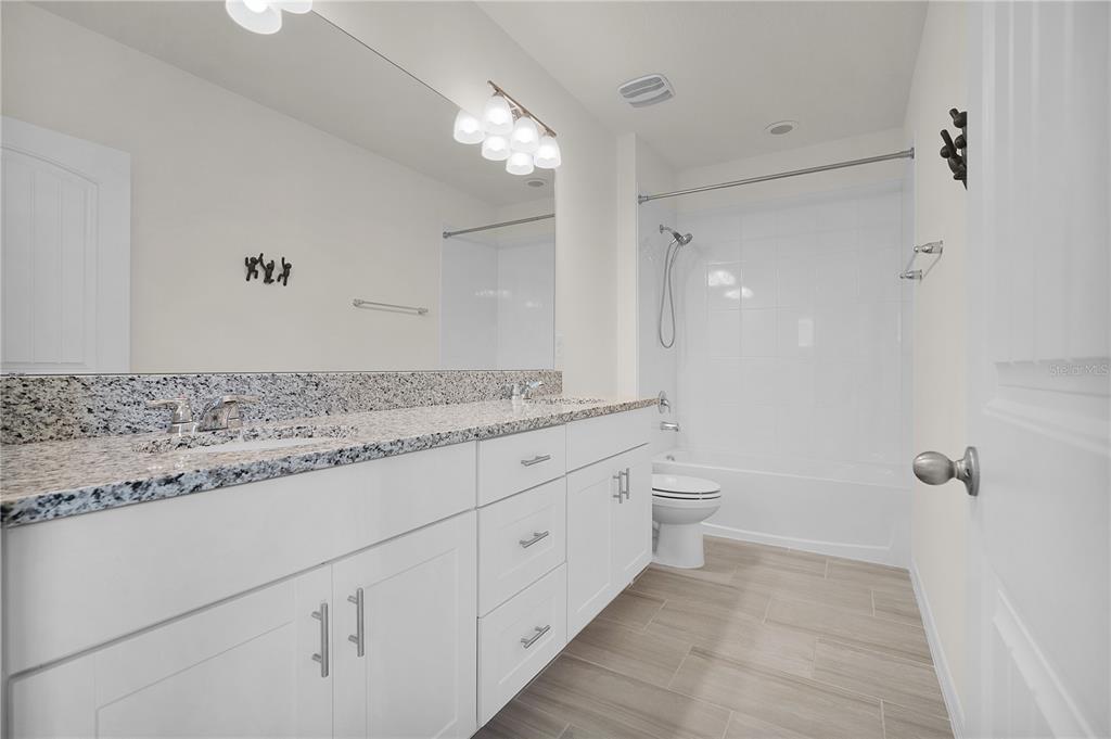 Undisclosed Address Winter Garden, FL 34787 - Photo 34 of 46 a bathroom with a granite countertop sink a toilet and shower