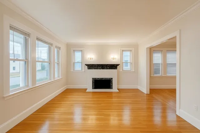 a view of a livingroom with wooden floor and a fireplace