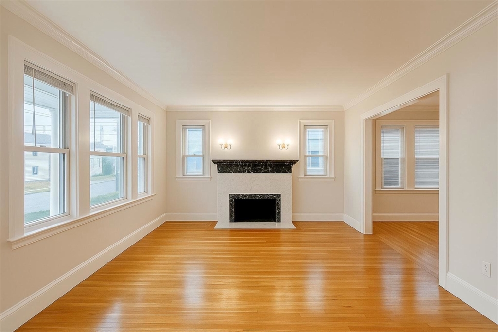 a view of a livingroom with wooden floor and a fireplace