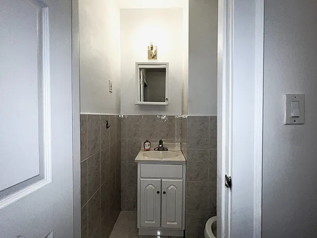 a bathroom with a sink and mirror with toilet