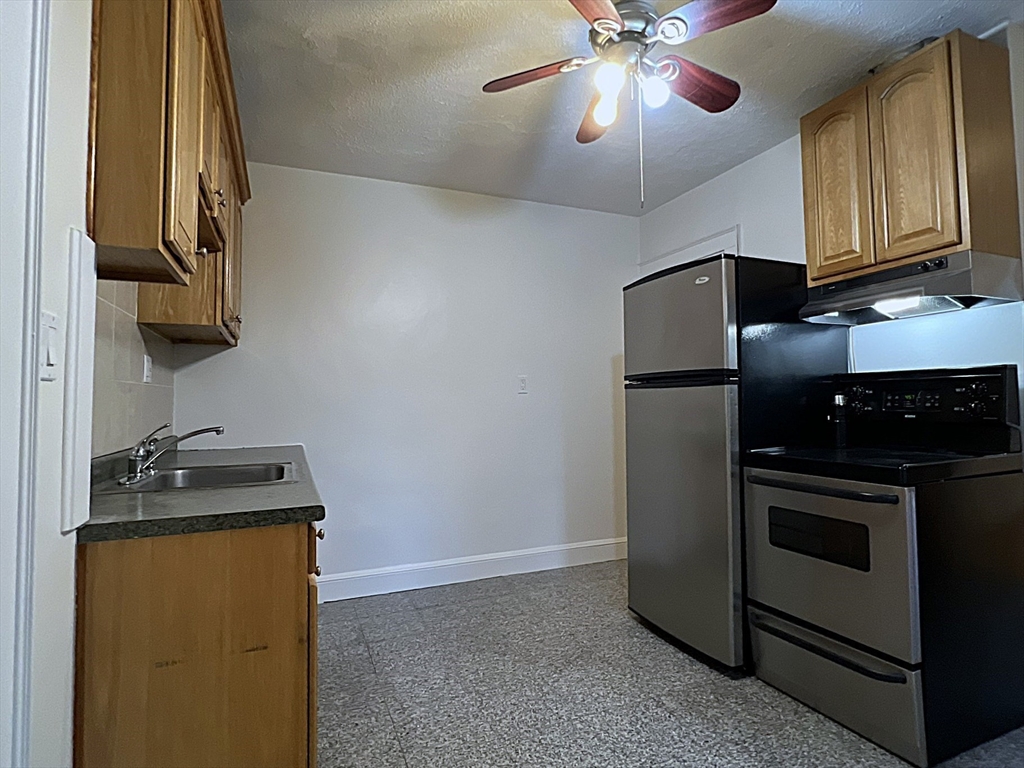 6 Oxford Avenue, Unit SIX Belmont, MA 02478 - Photo 5 of 13 a kitchen with stainless steel appliances granite countertop a stove a refrigerator and a microwave