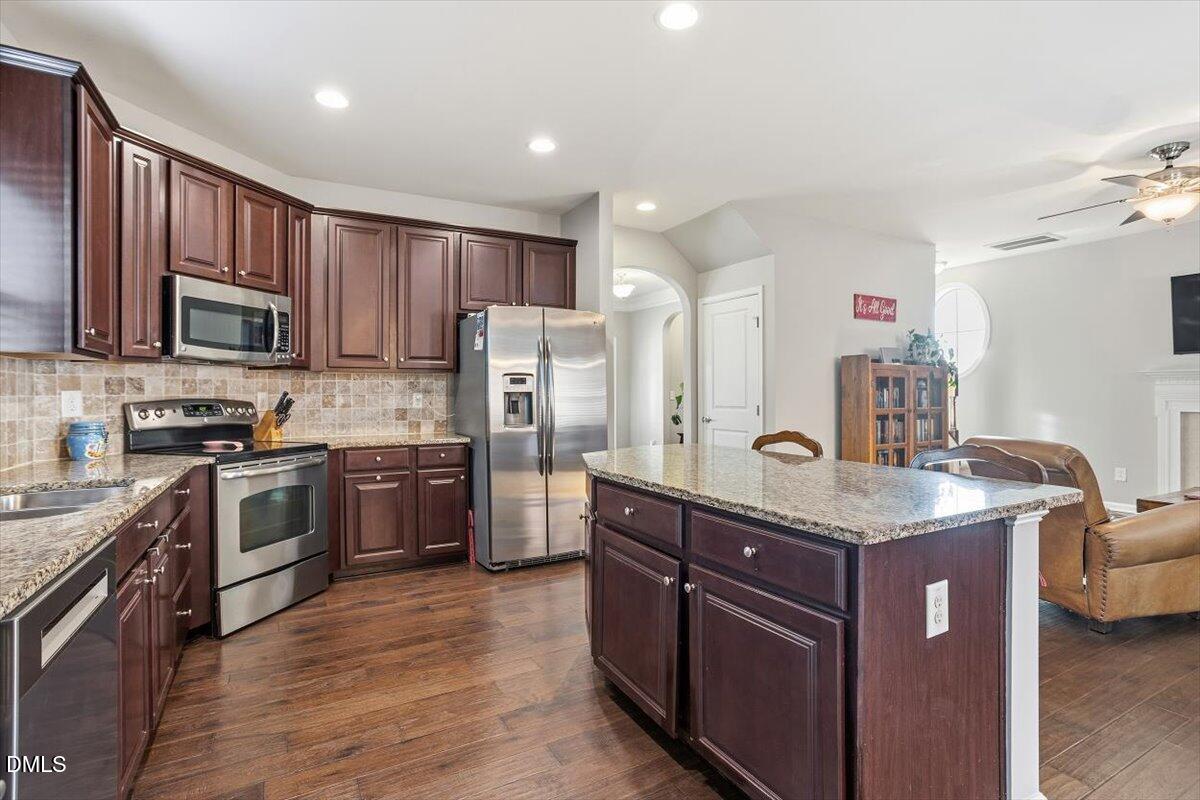 1500 Hemby Ridge Lane Morrisville, NC 27560 - Photo 11 of 50 a kitchen with kitchen island granite countertop stainless steel appliances and wooden cabinets