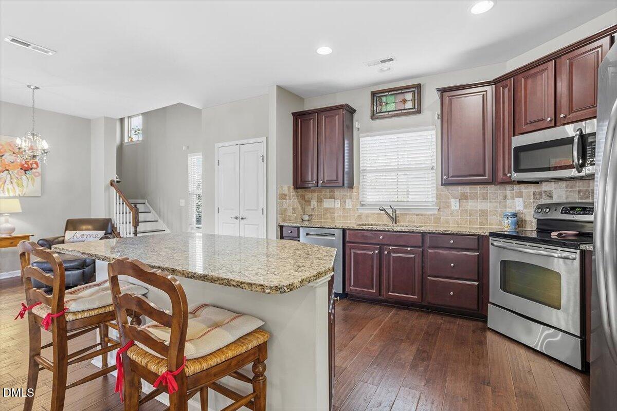 1500 Hemby Ridge Lane Morrisville, NC 27560 - Photo 9 of 50 a kitchen with stainless steel appliances granite countertop a stove a sink dishwasher a microwave oven and a refrigerator with wooden floor