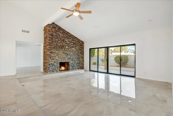 an empty room with windows and fireplace